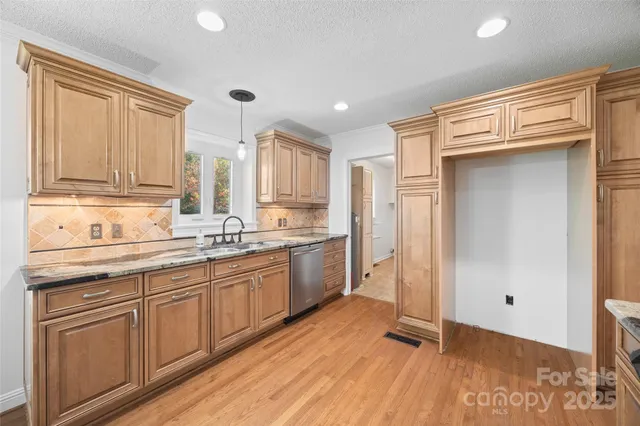 a kitchen with a sink cabinets stainless steel appliances and a window
