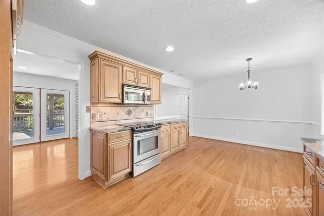 a kitchen with granite countertop a stove and a wooden floors