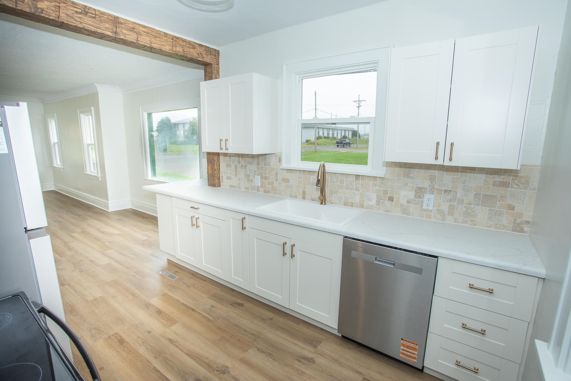 1923 North 28th Street Superior, WI 54880 - Photo 8 of 23 Kitchen featuring dishwasher, white cabinets, black range with electric cooktop, backsplash, and crown molding