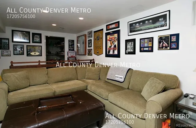 a living room with furniture and painting on the wall