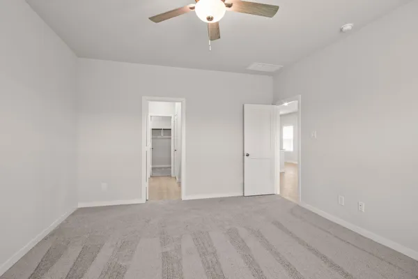 a view of an empty room with a chandelier fan