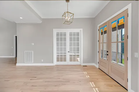 an empty room with windows fireplace and wooden floor