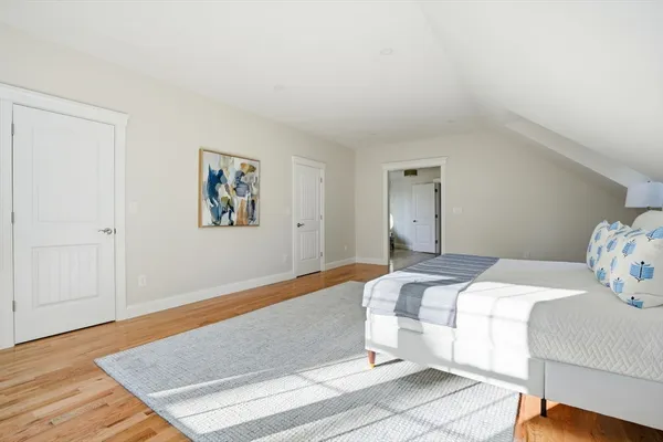 a bedroom with a bed and painting on the wall