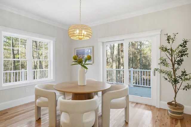 a view of a dining room with furniture a chandelier and wooden floor