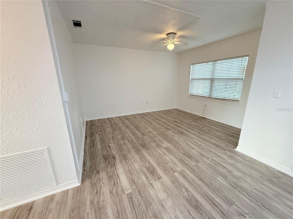 108 Booth Lane, Unit A Kissimmee, FL 34743 - Photo 6 of 19 wooden floor in an empty room with a window