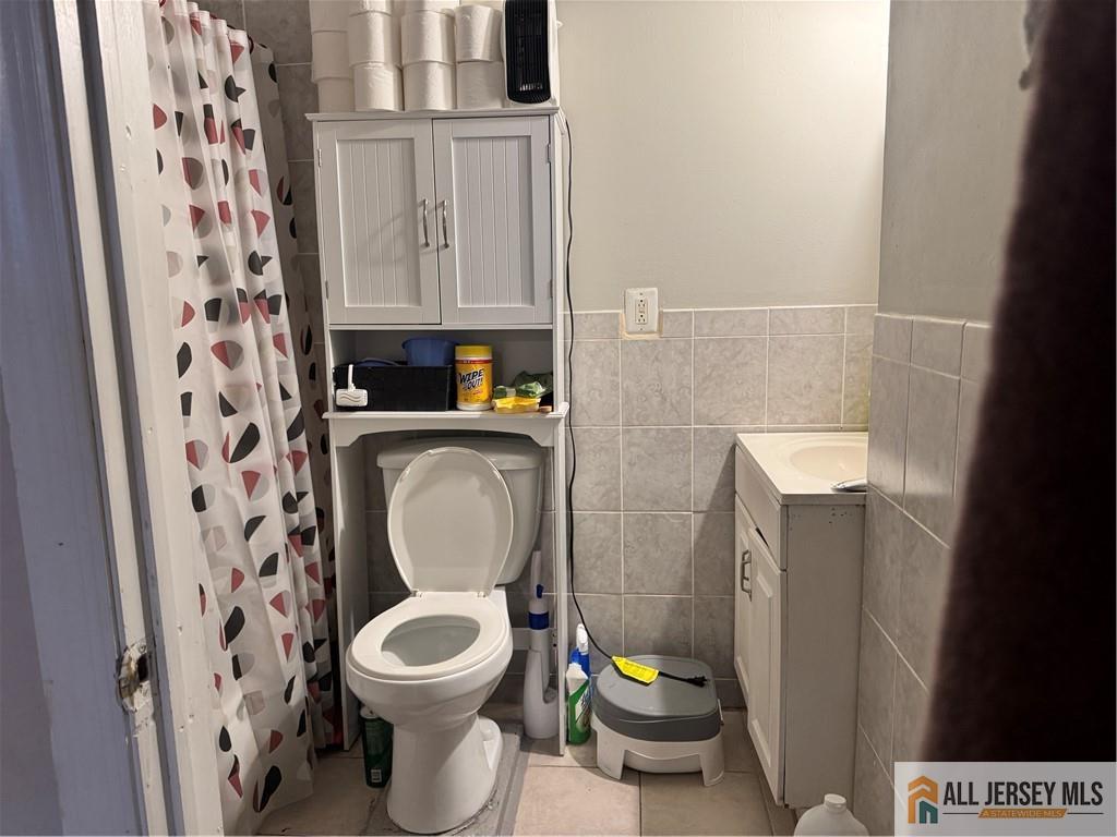 111 Delavan Street New Brunswick, NJ 08901 - Photo 13 of 28 a white toilet sitting next to a shower curtain