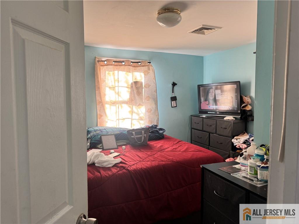 111 Delavan Street New Brunswick, NJ 08901 - Photo 24 of 28 a bedroom with a bed and a tv
