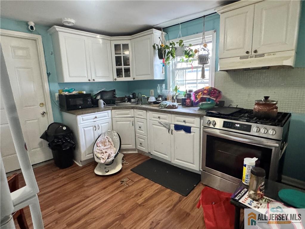 111 Delavan Street New Brunswick, NJ 08901 - Photo 8 of 28 a kitchen with granite countertop a stove a sink and a refrigerator