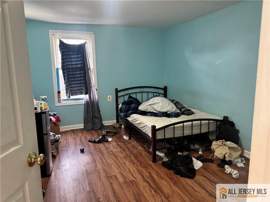 111 Delavan Street New Brunswick, NJ 08901 - Photo 10 of 28 a bedroom with a bed and wooden floor