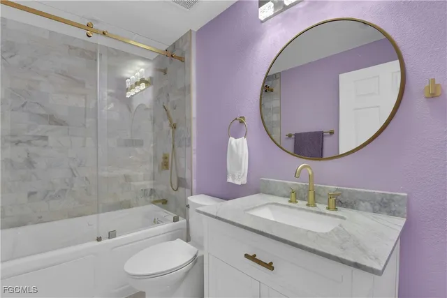 a bathroom with a granite countertop sink mirror toilet and bathtub