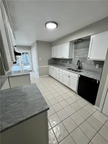 a kitchen with granite countertop a sink and cabinets
