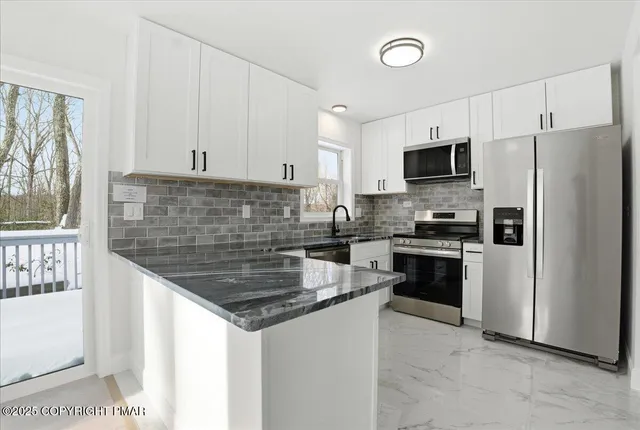 a large kitchen with kitchen island granite countertop a refrigerator and a sink