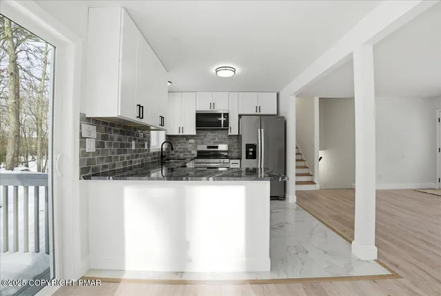 a kitchen with stainless steel appliances a refrigerator and a stove top oven