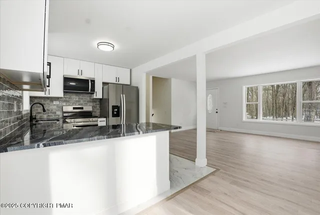 a kitchen with granite countertop a refrigerator sink and stove