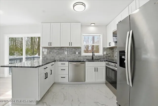 a kitchen with granite countertop white cabinets and a window