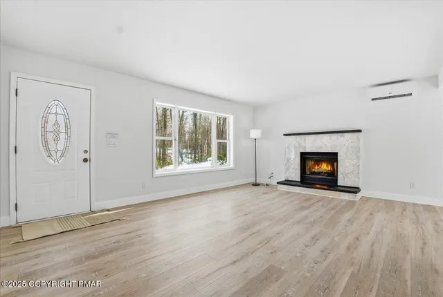 an empty room with windows and fireplace