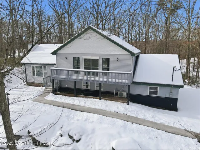 a view of a house with a yard covered in snow
