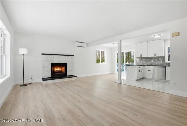 a view of empty room with wooden floor and fireplace