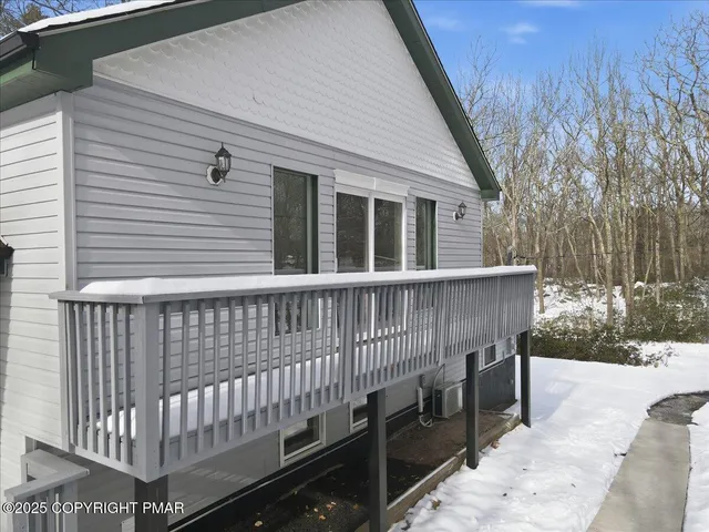 a backyard of a house with large trees and covered wooden fence