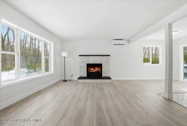 a view of an empty room with a window and fireplace