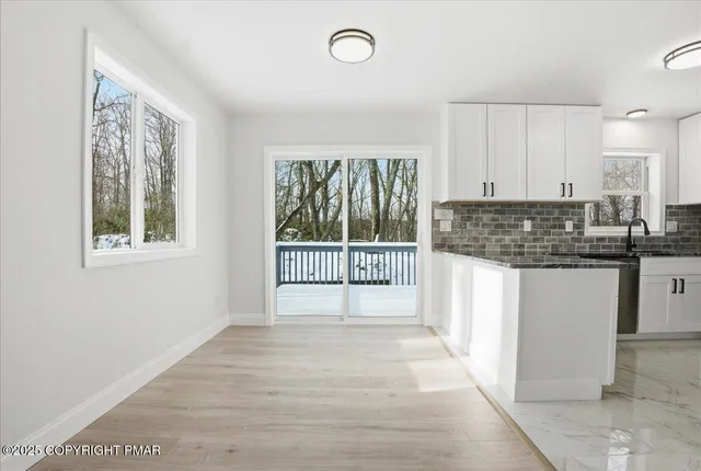 a view of a kitchen with a sink and dishwasher cabinet with wooden floor