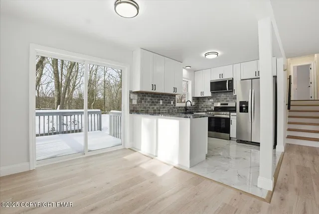 a kitchen with stainless steel appliances granite countertop a stove a sink and a microwave