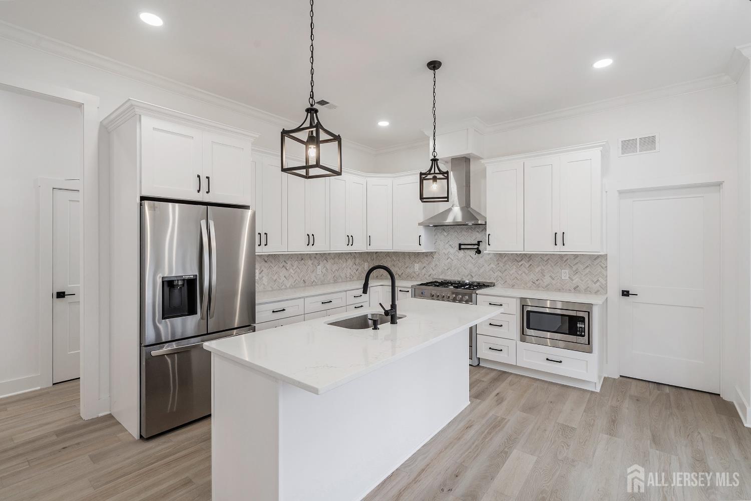 34 Mill Road Manalapan, NJ 07726 - Photo 6 of 30 a kitchen with stainless steel appliances granite countertop a sink a stove a refrigerator and island with wooden floor