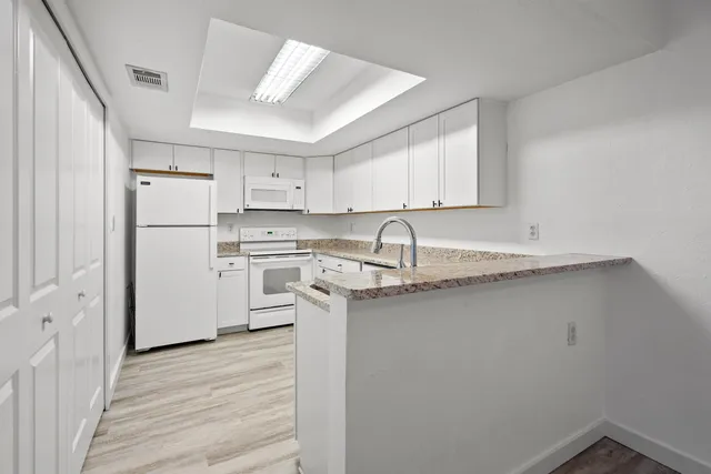 a kitchen with a sink stainless steel appliances and white cabinets