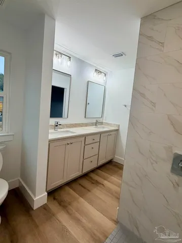 a bathroom with a double vanity sink mirror and bathtub