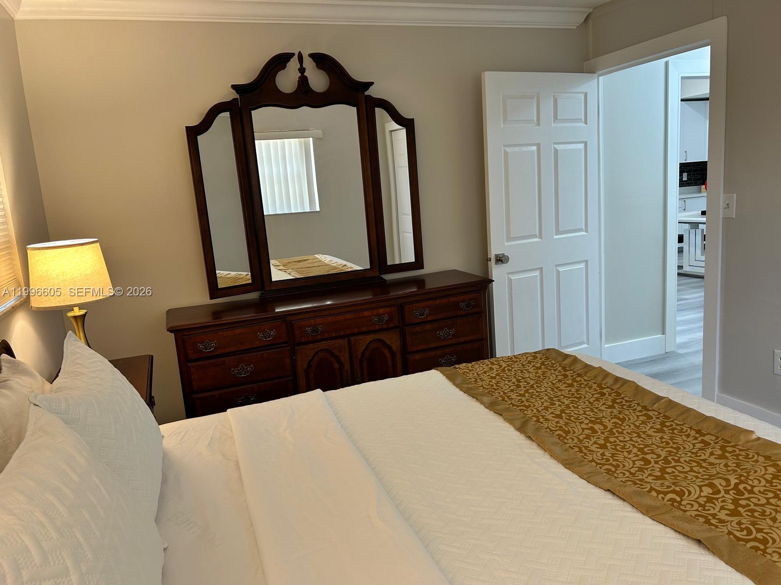 9922 Southwest 2nd Street, Unit A Miami, FL 33174 - Photo 13 of 24 a bedroom with a bed and a mirror on dresser