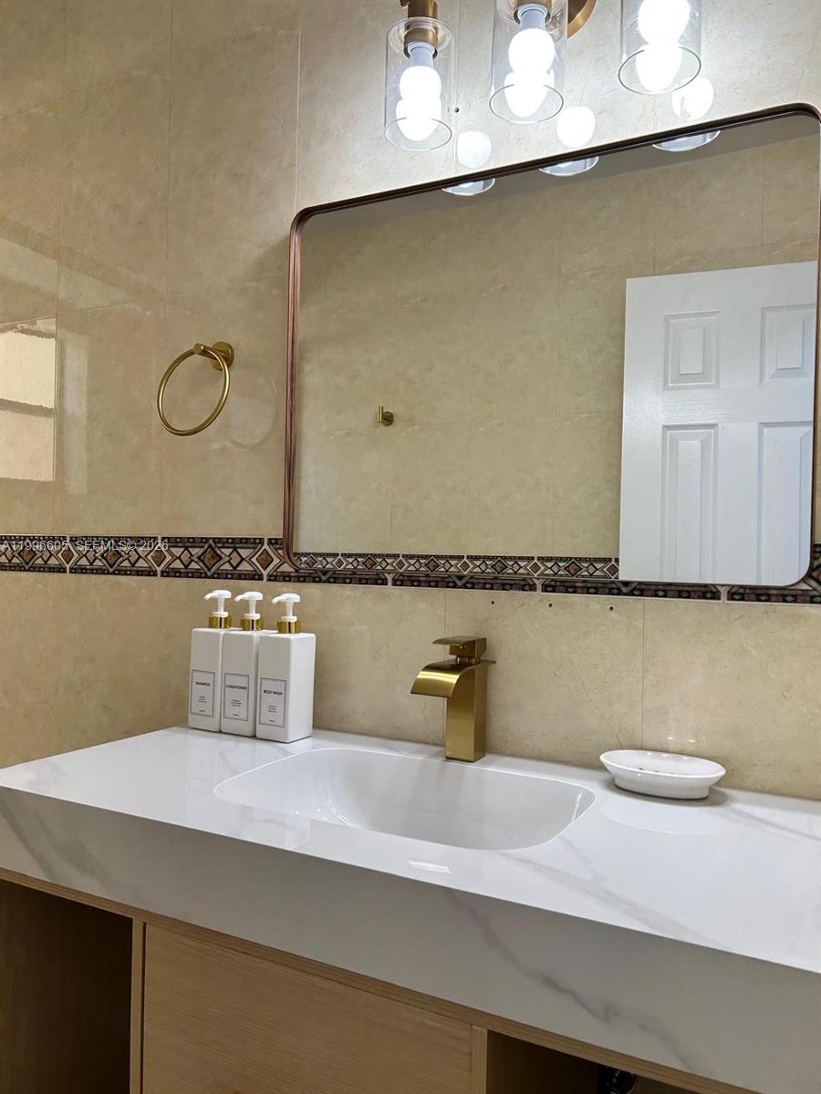 9922 Southwest 2nd Street, Unit A Miami, FL 33174 - Photo 16 of 24 a bathroom with a granite countertop sink and a mirror