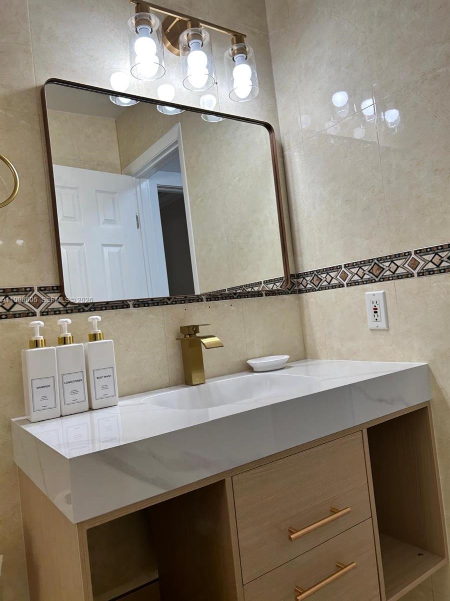 9922 Southwest 2nd Street, Unit A Miami, FL 33174 - Photo 17 of 24 a bathroom with a sink and a mirror