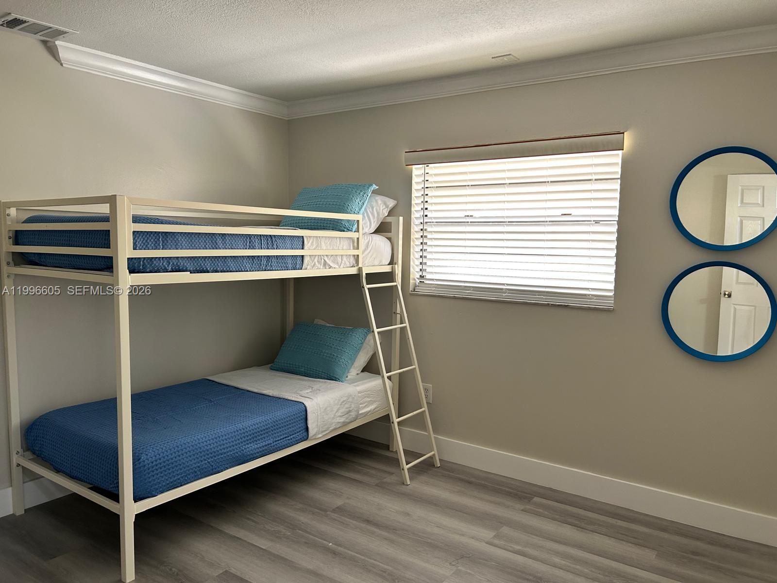 9922 Southwest 2nd Street, Unit A Miami, FL 33174 - Photo 18 of 24 a bedroom with a bed and a window