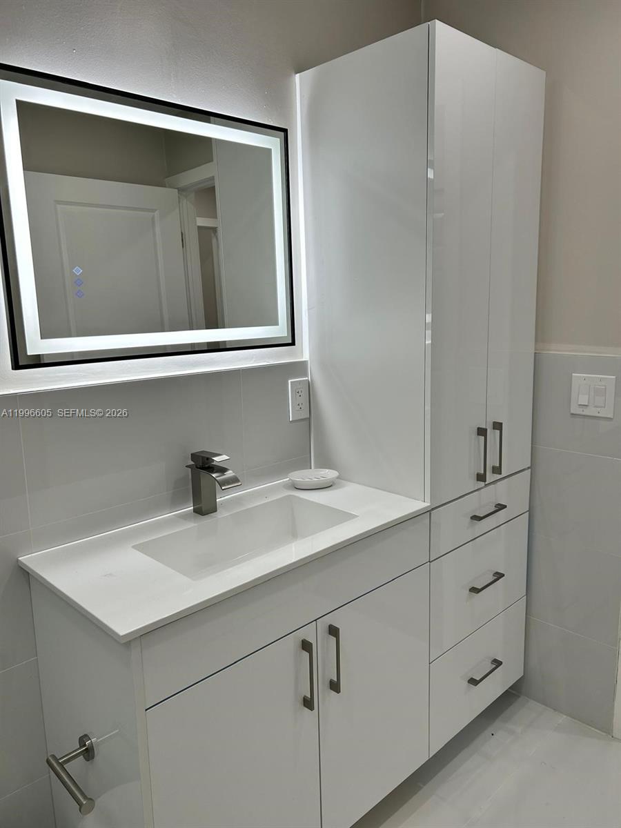 9922 Southwest 2nd Street, Unit A Miami, FL 33174 - Photo 20 of 24 a bathroom with a sink and a mirror