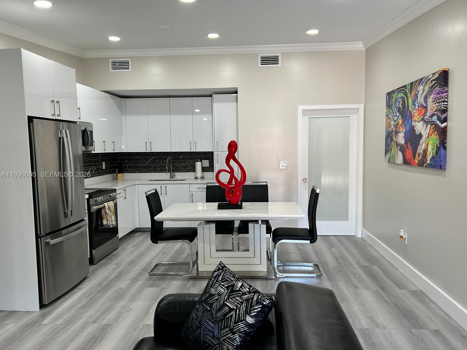 9922 Southwest 2nd Street, Unit A Miami, FL 33174 - Photo 4 of 24 a living room with furniture a refrigerator and kitchen view
