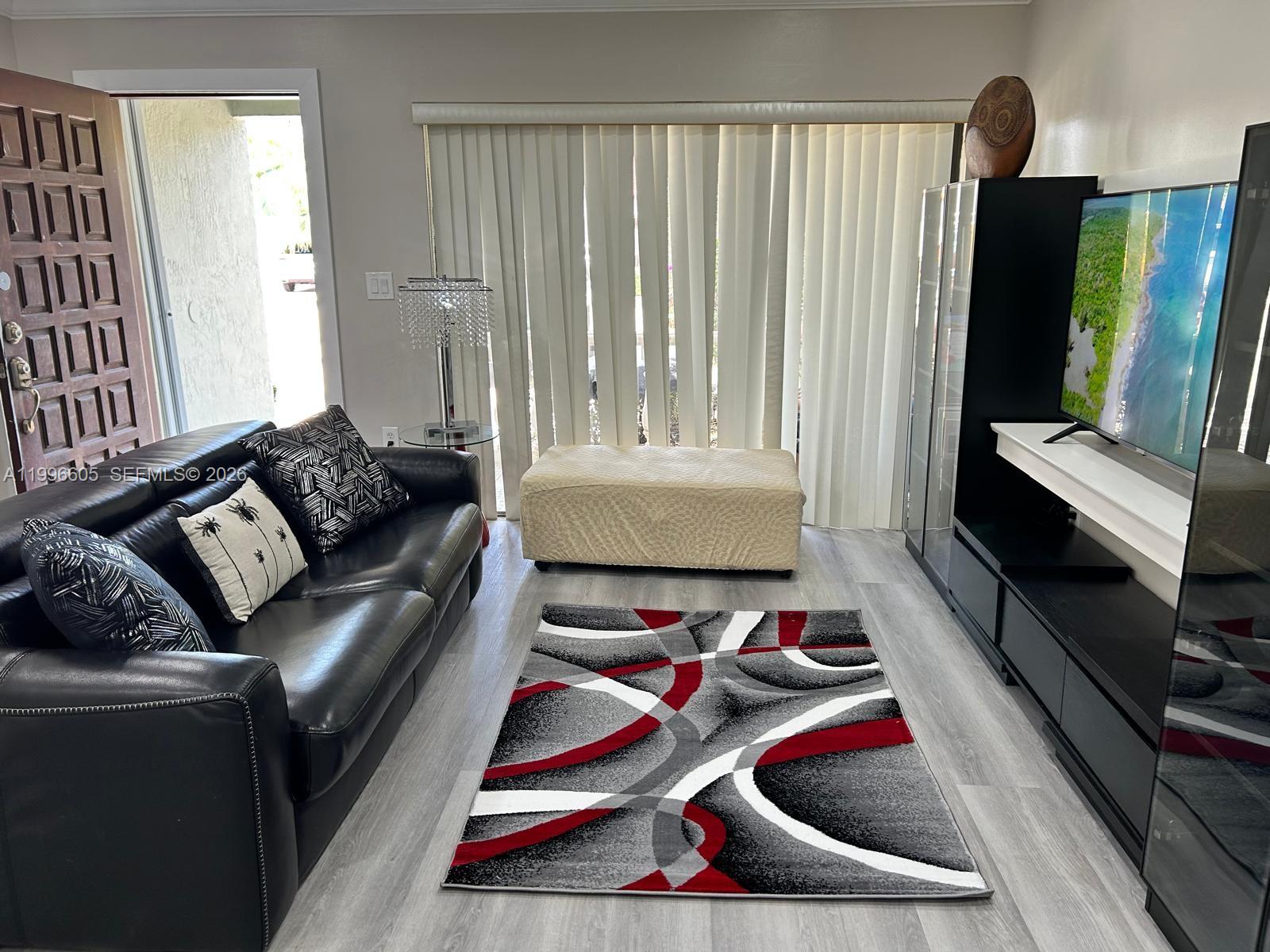 9922 Southwest 2nd Street, Unit A Miami, FL 33174 - Photo 5 of 24 a living room with furniture and a flat screen tv
