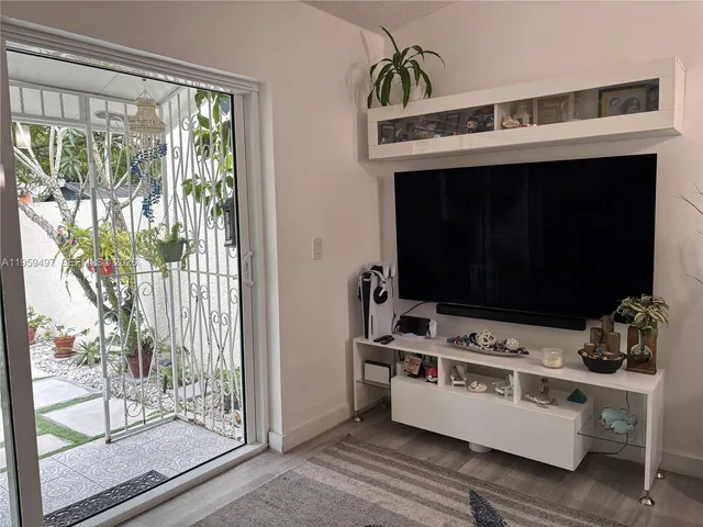 a room with furniture a flat screen tv and a floor to ceiling window
