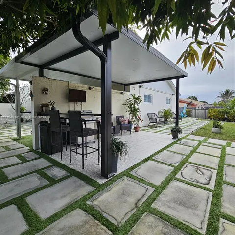 a view of a patio with a table and chairs under an umbrella