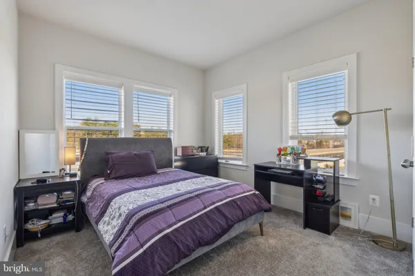 a bedroom with a bed and a lamp on the dresser