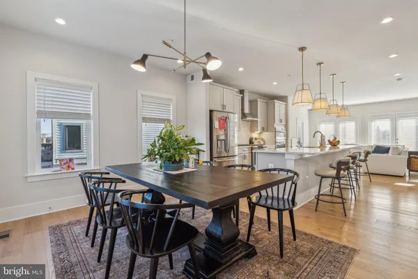 a large kitchen with kitchen island a stove a sink a center island and wooden floor