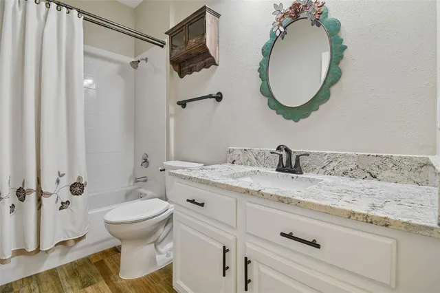 a view of empty room with wooden floor and ceiling fan