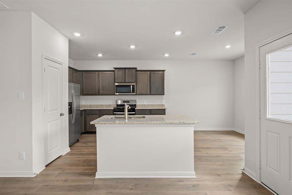 521-a D A D Crain Street Venus, TX 76084 - Photo 2 of 17 a kitchen with stainless steel appliances granite countertop a sink dishwasher a refrigerator and a stove with wooden floor