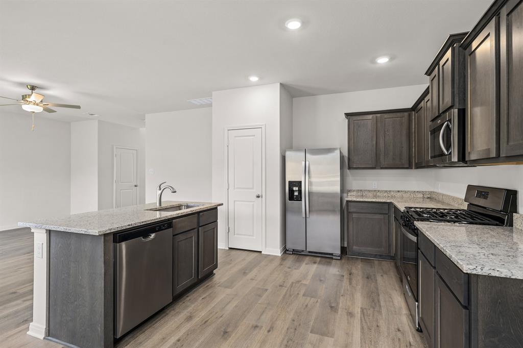 521-a D A D Crain Street Venus, TX 76084 - Photo 4 of 17 a kitchen with stainless steel appliances granite countertop a sink stove and refrigerator