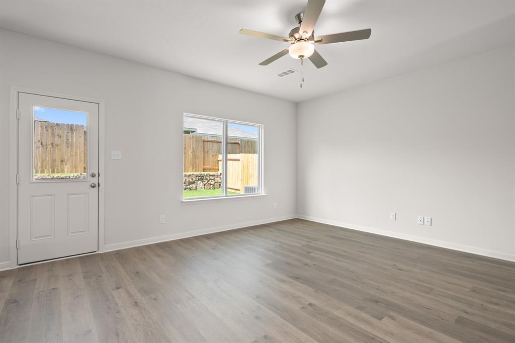 521-a D A D Crain Street Venus, TX 76084 - Photo 9 of 17 an empty room with wooden floor ceiling fan and windows