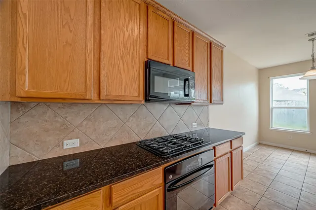 a kitchen with granite countertop a sink counter top space and cabinets