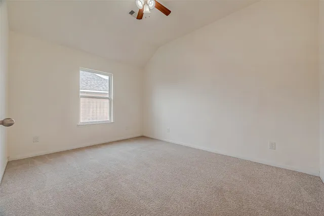 an empty room with a ceiling fan and window