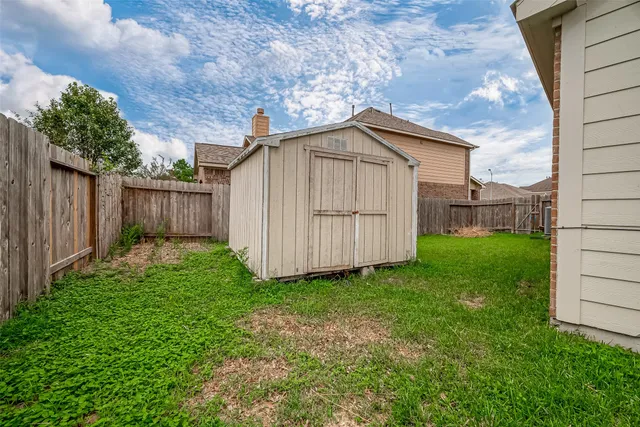 a view of a house with a yard and wooden fence