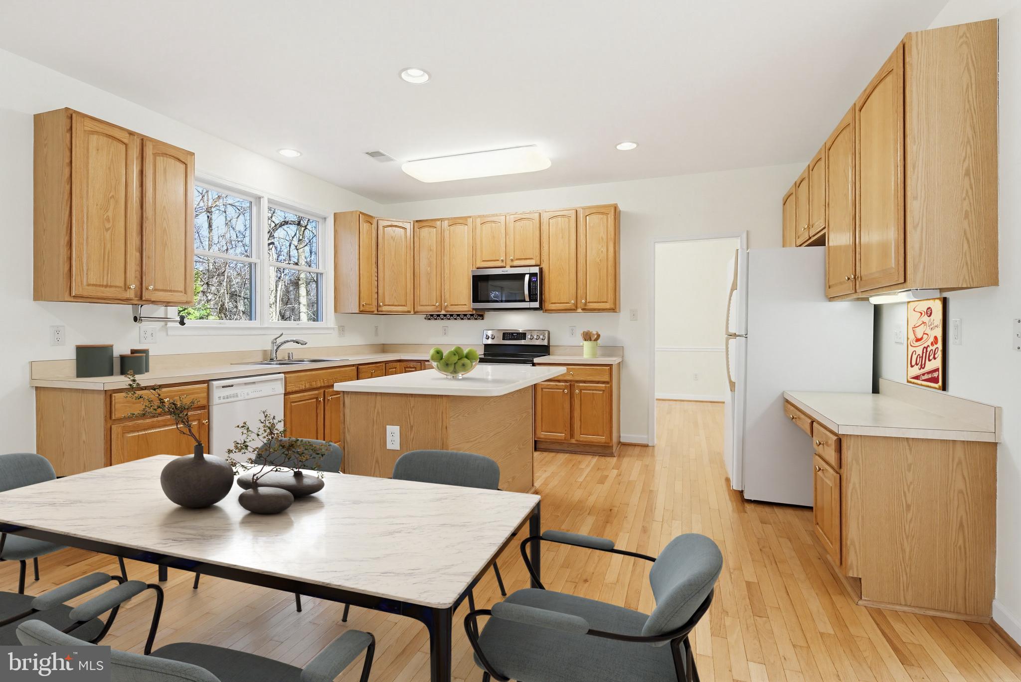 12017 Floating Clouds Path Clarksville, MD 21029 - Photo 6 of 54 a kitchen with a table chairs a sink dishwasher stove and cabinets with wooden floor