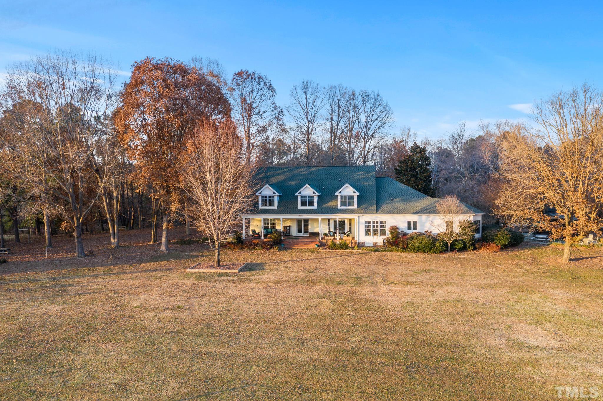 1616 Carl Durham Road Chapel Hill, NC 27516 - Photo 1 of 56 a view of a large house with a big yard and large trees