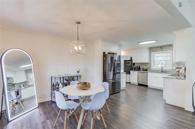 a kitchen with refrigerator and wooden floor